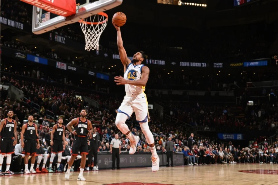 一位NBA明星球员在季后赛中奋力上篮，背景为聚焦的观众和队友